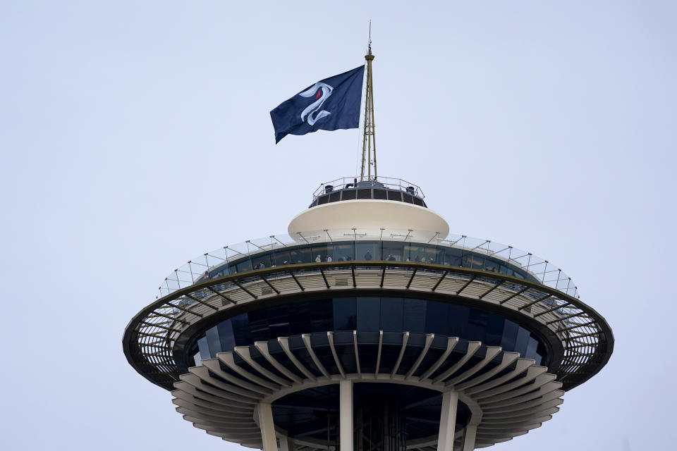 A Seattle Kraken hockey team flag flies atop the Space Needle on Saturday afternoon, Oct. 23, 2021, in Seattle, before the Kraken's inaugural home match as the newest NHL team, against the Vancouver Canucks later Saturday. (AP Photo/Elaine Thompson)