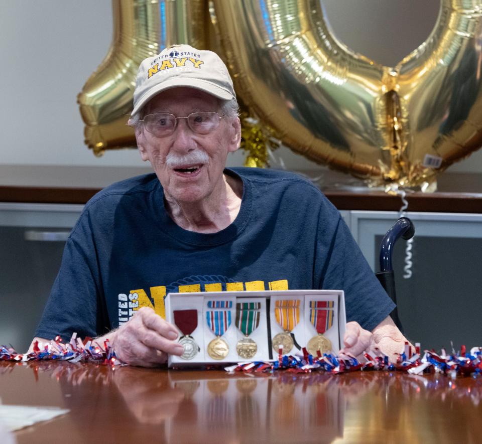 Navy veteran Ralph Morris shows off the new service medals he received as a present on his 100th birthday Monday. Morris, his family, friends and caregivers threw the centenarian a birthday bash at the Veterans Administration's Joint Ambulatory Care Center in Pensacola.