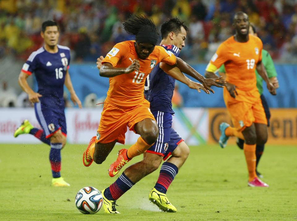 Ivory Coast's Gervinho (2nd L) fights for the ball with Japan's Shinji Okazaki (C) during their 2014 World Cup Group C soccer match at the Pernambuco arena in Recife, June 14, 2014. REUTERS/Stefano Rellandini