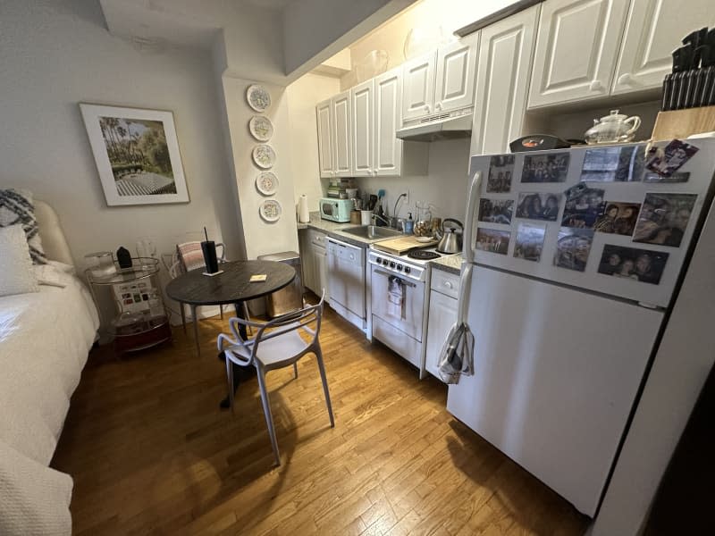 White kitchen with white cabinets next to a dining area.