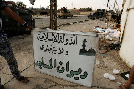 A sign which reads "Islamic State, Nineveh Governorate, Council of Mosques" is seen along a street of the town of al-Shura, which was recaptured from Islamic State (IS) on Saturday, south of Mosul, Iraq October 30, 2016. REUTERS/Zohra Bensemra