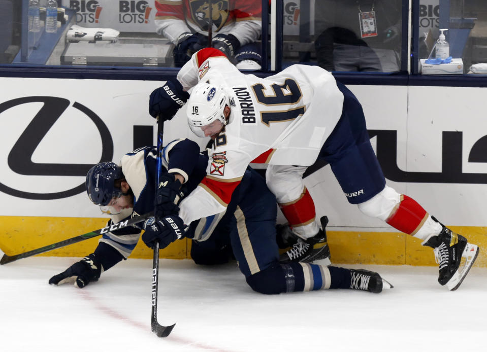 Florida Panthers forward Aleksander Barkov, top, of Finland, checks Columbus Blue Jackets forward Kevin Stenlund, of Sweden, during the first period of an NHL hockey game in Columbus, Ohio, Tuesday, Jan. 26, 2021. (AP Photo/Paul Vernon)