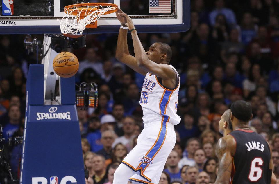 Oklahoma City Thunder forward Kevin Durant dunks in front of Miami Heat forward LeBron James (6) during the first quarter of an NBA basketball game in Oklahoma City, Thursday, Feb. 20, 2014. (AP Photo/Sue Ogrocki)