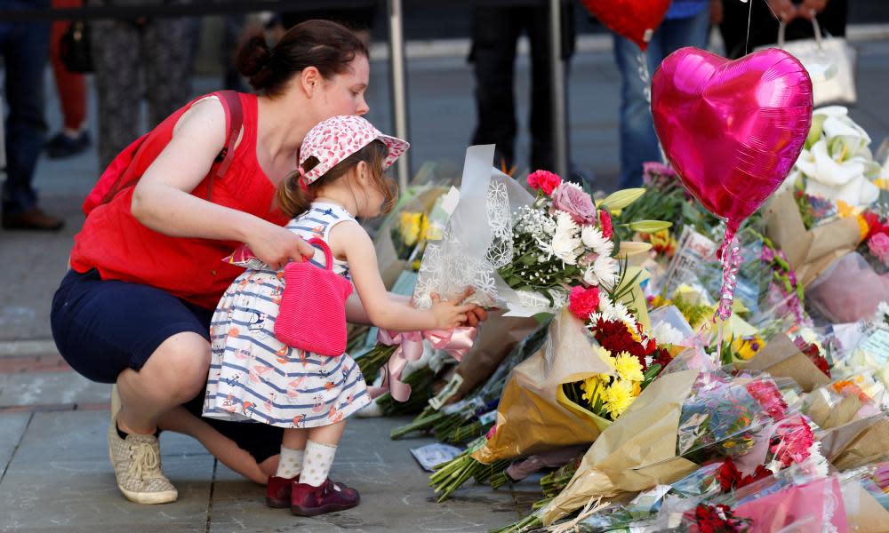 woman and girl leave flowers in Manchester