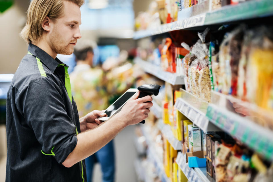 An employee scanning groceries on the shelf