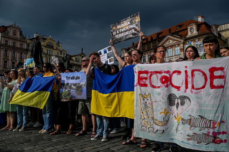 Personas con pancartas y banderas ucranianas participan en la protesta antirrusa contra la destrucción de la presa de Kajovka, controlada por Rusia, en la Plaza de la Ciudad Vieja de Praga, República Checa, el 10 de junio de 2023.