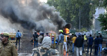 LUCKNOW, INDIA - DECEMBER 19: Police personnel gather during near a burning and damaged vehicles during an anti Citizenship Amendment Act (CAA) and National Register of Citizens (NRC) protest at Parivartan Chowk area on December 19, 2019 in Lucknow, India. The act seeks to grant Indian citizenship to refugees from Hindu, Christian, Sikh, Buddhist and Parsi communities fleeing religious persecution from Pakistan, Afghanistan, and Bangladesh, and who entered India on or before December 31, 2014. The Parliament had passed the Citizenship (Amendment) Bill, 2019 last week and it became an act after receiving assent from President Ram Nath Kovind. Since then, protests including some violent ones have erupted in various regions of the country, including the North East over the amended citizenship law. (Photo by Dheeraj Dhawan/Hindustan Times via Getty Images)