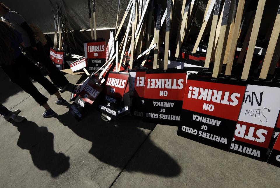 WGA members turn in their signs at the end of their first day of their strike in front of Paramount Studios