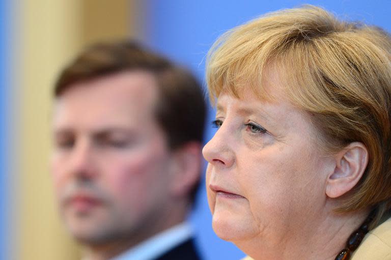 German chancellor Angela Merkel (R) sits next to her spokesman Steffen Seibert as she gives a press conference on September 17, 2012 in Berlin