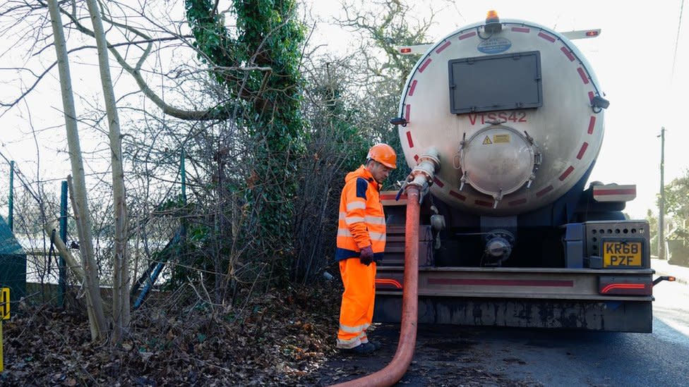 A man from a sewage treatment company beside a tanker
