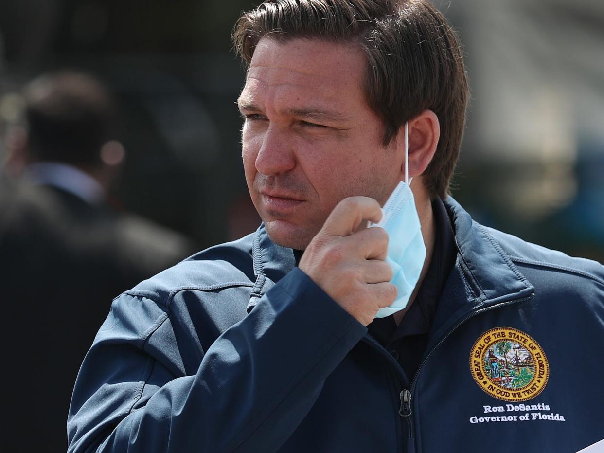 MIAMI GARDENS, FLORIDA - MAY 06: Florida Gov. Ron DeSantis takes his mask off as he prepares to speak during a press conference at the Hard Rock Stadium testing site on May 06, 2020 in Miami Gardens, Florida. Gov. DeSantis announced during the press conference that a COVID-19 antibodies test will be available. The test can show if a person has had the virus in the past without showing symptoms, and therefore may be immune to it. The test will be available to first responders and health care workers first, with the goal of being able to expand testing to the general public.