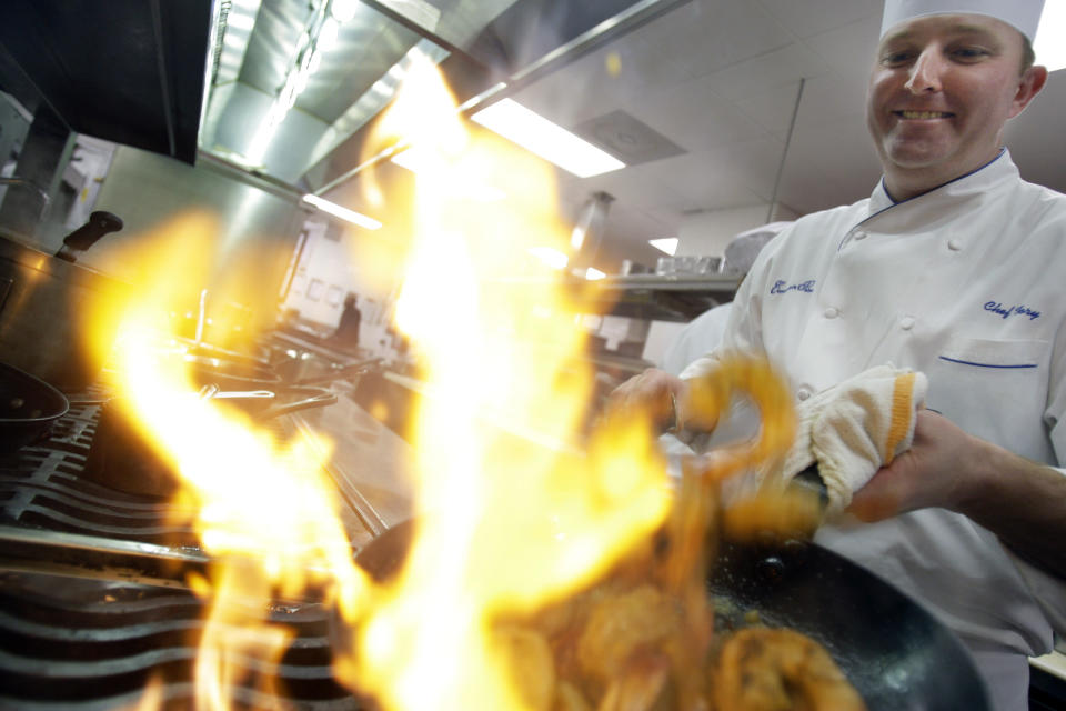 FILE - In this Wednesday, Jan. 7, 2009 file photo, Executive Chef Tory McPhail cooks Lemon and Garlic Crusted Wild Shrimp at Commander's Palace in the Garden District of New Orleans. Tory McPhail, who has been the executive chef at Commander’s Palace for 19 years, marked his last day at the legendary restaurant on Thanksgiving, Nov. 26, 2020. He is moving to Bozeman, Montana. (AP Photo/Alex Brandon, File)