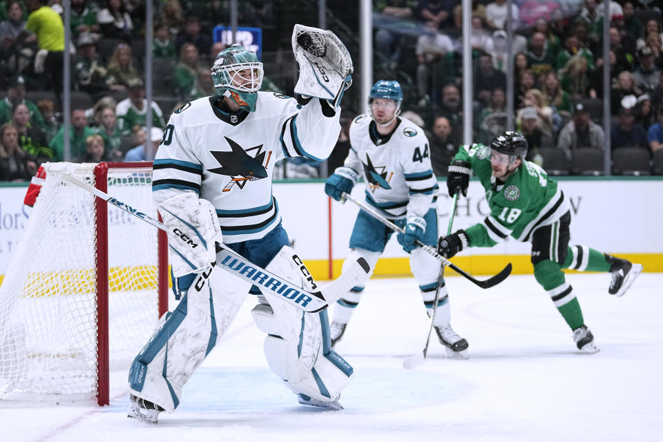 San Jose Sharks goaltender Magnus Chrona (30) gloves the puck as Marc-Edouard Vlasic (44) helps defend on the play against Dallas Stars center Sam Steel (18) during the first period of an NHL hockey game Saturday, March 2, 2024, in Dallas. (AP Photo/Tony Gutierrez)