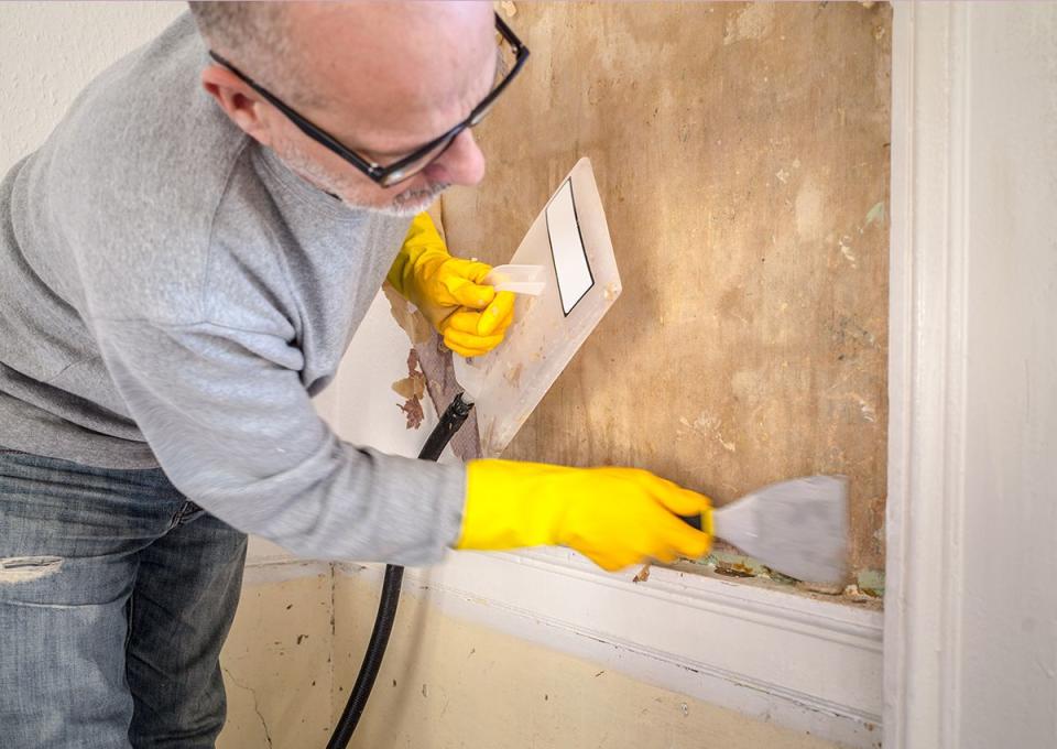 person removing wallpaper how to remove wallpaper