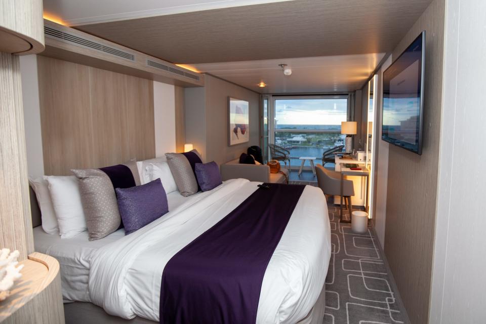 the bedroom with windows that overlook the water