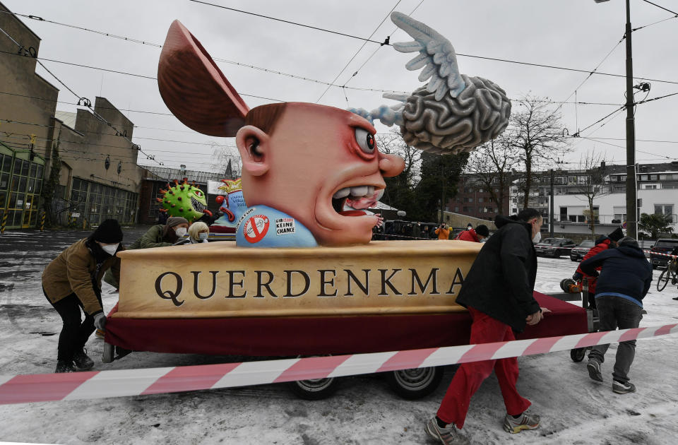 A political carnival float depicting conspiracy theorists is rolled out to be shown in Duesseldorf, Germany, Monday, Feb. 15, 2021. Because of the coronavirus pandemic the traditional 'Rosenmontag' carnival parade are canceled but eight floats are pulled through the empty streets in Duesseldorf, where normally hundreds of thousands of people would celebrate the street carnival. (AP Photo/Martin Meissner)