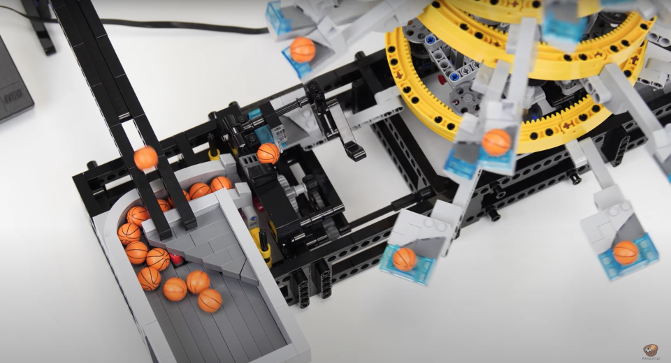 Small, toy basketballs moving their way down a pointless yet beautiful LEGO machine.