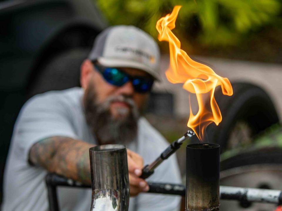 Jason Fulton of Palm Springs uses a torch to light a propane flame in the pipe his 1926 Ford Model T entered in the Muscle on the Beach Car Show at Old School Square in Delray Beach, featuring American Muscle cars, trucks and hot rods of the 50Õs, 60Õs and 70Õs March 2, 2024.