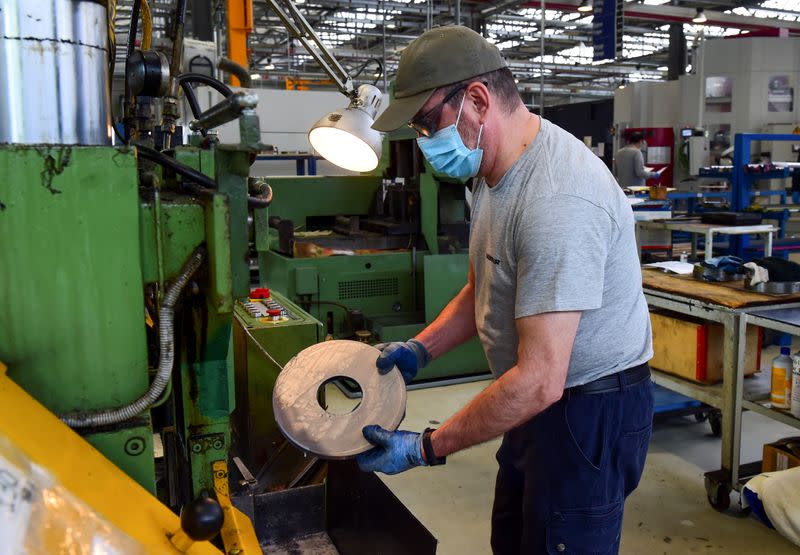 FOTO DE ARCHIVO: Un trabajador de la empresa manufacturera Liebherr, usa mascarilla y guantes mientras trabaja en la fábrica un día después de su reapertura en Collegno, Italia, el 5 de mayo de 2020