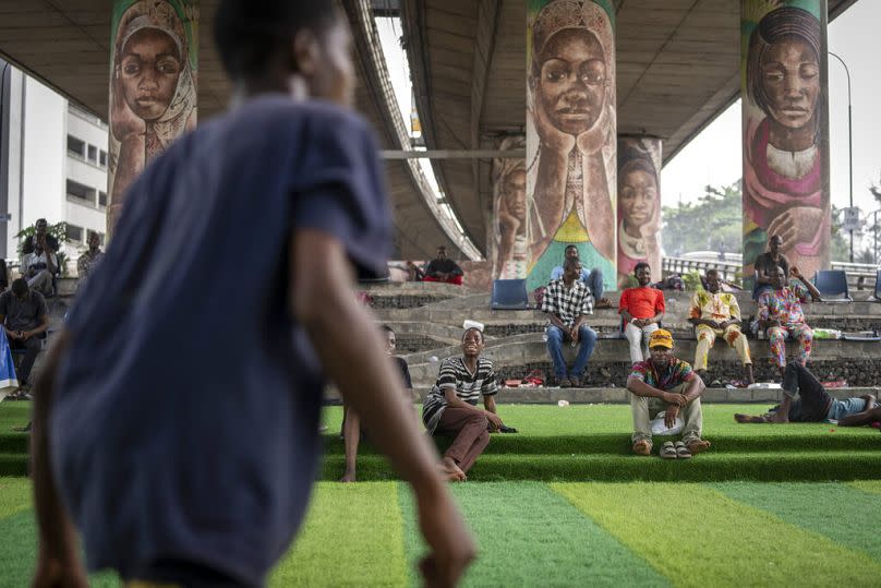 A teammate shouts out as youth play football underneath a highway bridge on Ikoyi Island, Lagos, February 2023