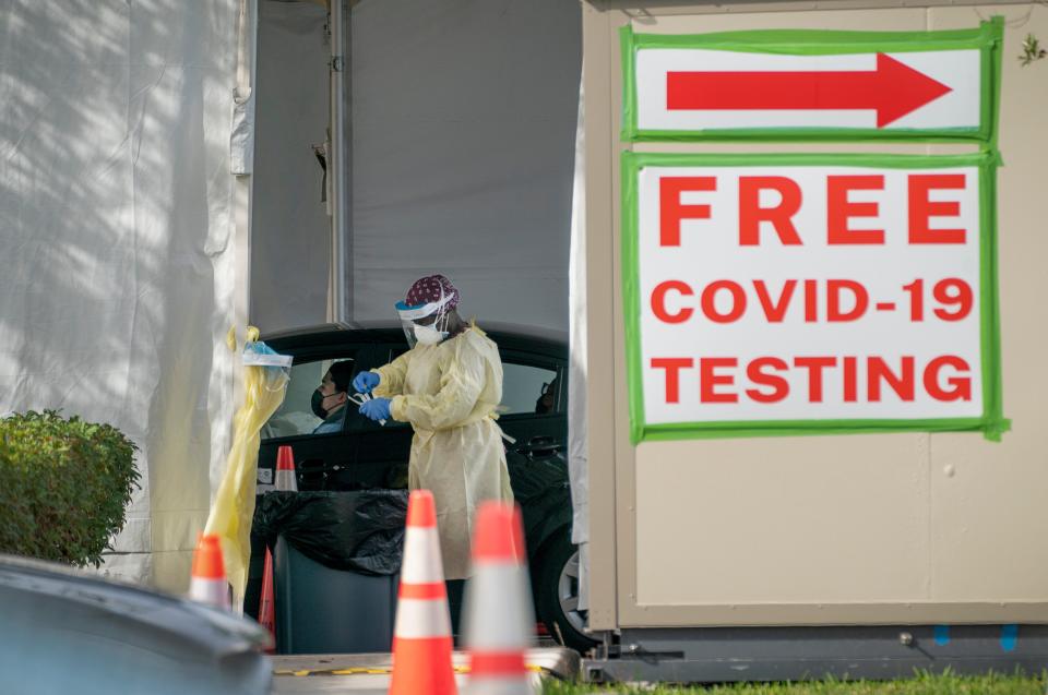 A healthcare worker testing people for COVID-19 outside the Gardens Branch Library in Palm Beach Gardens, Florida on December 20, 2021.