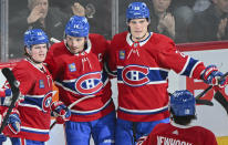 Montreal Canadiens' Nick Suzuki (14) celebrates with teammates Cole Caufield (22) and Juraj Slafkovsky (20) after scoring against the Florida Panthers during the second period of an NHL hockey game in Montreal, Tuesday, April 2, 2024. (Graham Hughes/The Canadian Press via AP)