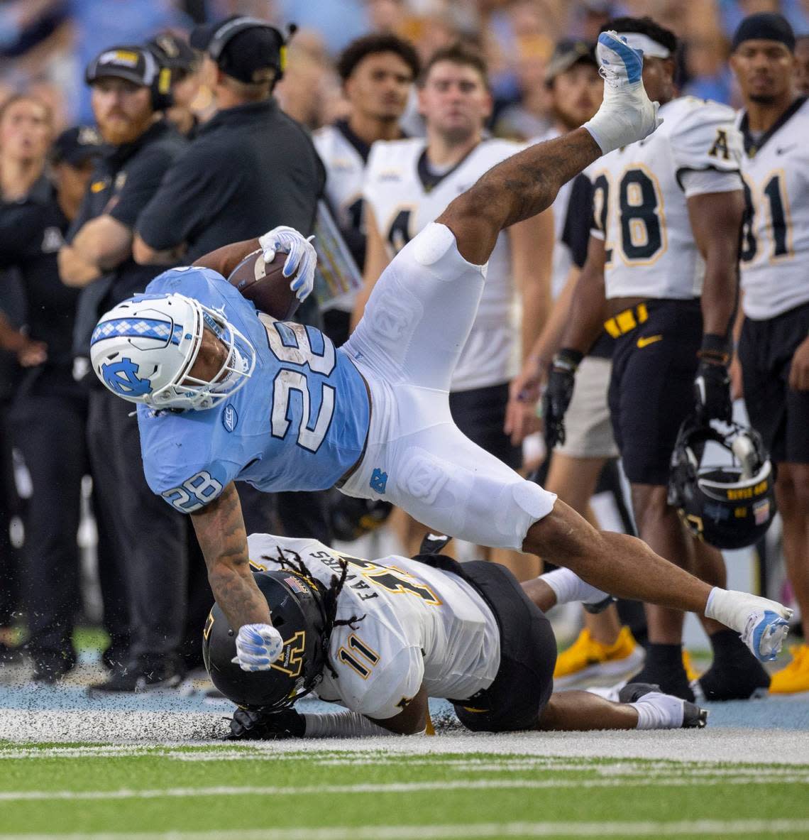 North Carolina running back Omarion Hampton (28) hurdles over Appalachian State’s Jordan Favors (11) after a 31-yard gain in the second quarter on Saturday September 9, 2023 at Kenan Stadium in Chapel Hill, N.C.