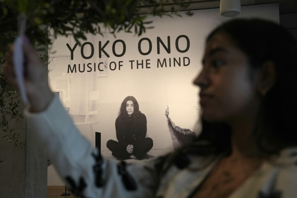 A member of staff hangs a note on a work entitled Wish Trees for London, first realisation Wish Tree 1996, exhibition realisation 2024, at the Yoko Ono : Music of the Mind exhibition at the Tate Modern, the works of art are copyright Yoko Ono, In London, Tuesday, Feb. 13, 2024. The Exhibition which has many pieces that are interactive and the public and participate in, runs from Feb.15, to Sept. 1. (AP Photo/Alastair Grant)