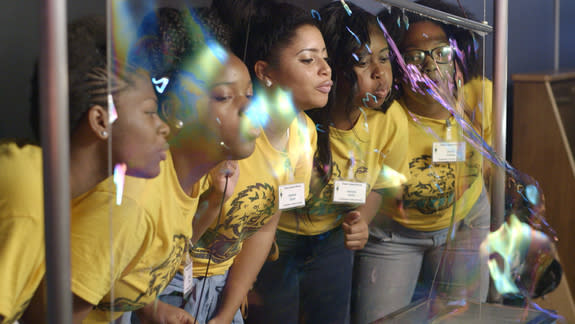 Students visiting the LIGO Science Education Center learn about surface tension and the refraction of light with a massive bubble wall. LIGO Observatory, Livingston, Louisiana.