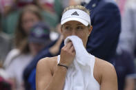 Germany's Angelique Kerber wipes her face before serving to stay in the game in the second set against Belgium's Elise Mertens in a third round women's singles match on day five of the Wimbledon tennis championships in London, Friday, July 1, 2022. (AP Photo/Alastair Grant)