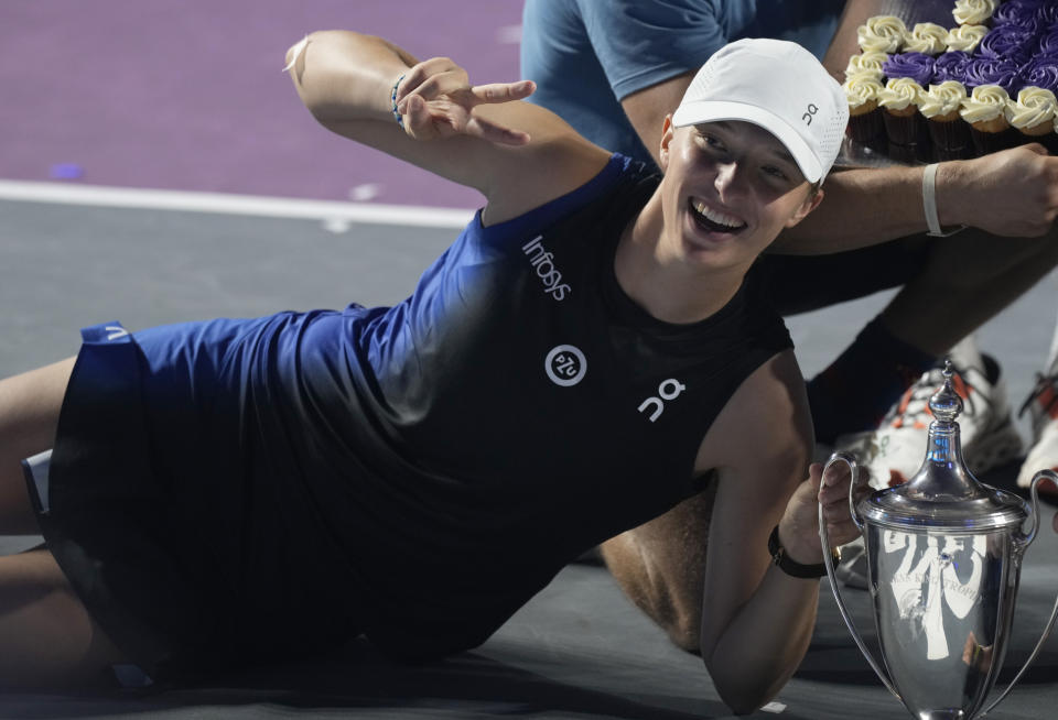 FILE - Iga Swiatek poses with her trophy after her victory over Jessica Pegula in the singles final of the WTA Finals tennis championships, in Cancun, Mexico, Monday, Nov. 6, 2023. Saudi Arabia will host the WTA Finals as part of a three-year deal announced Thursday, April 4, 2024, by the women’s professional tennis tour that will increase the prize money for this November’s season-ending championship to a record $15.25 million, a 70% increase from 2023. (AP Photo/Fernando Llano, File)