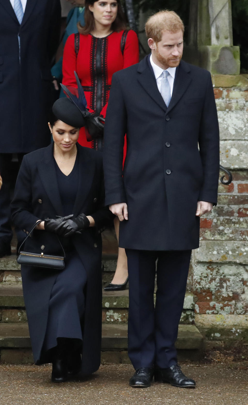 Britain's Prince Harry, stands with Meghan, Duchess of Sussex as she does a curtsy to Britain's Queen Elizabeth II as she leaves in a car after attending the Christmas day service at St Mary Magdalene Church in Sandringham in Norfolk, England, Tuesday, Dec. 25, 2018. (AP Photo/Frank Augstein)