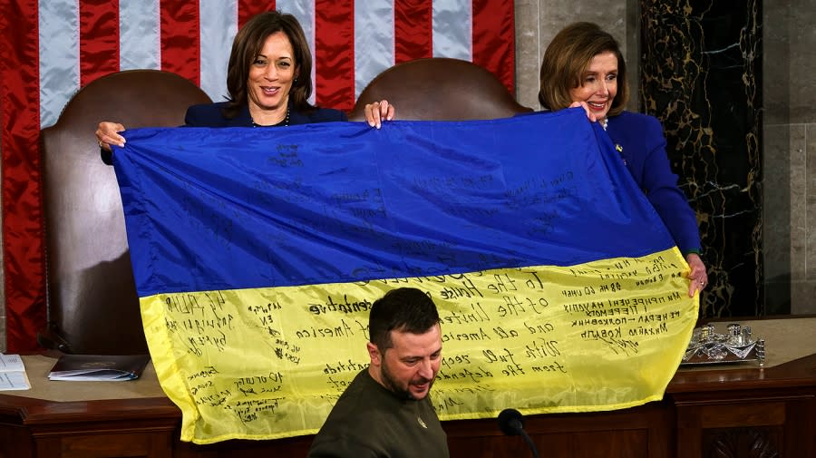 Vice President Harris and Speaker Nancy Pelosi (D-Calif.) hold a Ukrainian flag given by President Volodymyr Zelensky