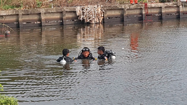 Picture of divers searching the pond on Apichai Ongwisit's property, after the remains of his girlfriend were discovered 