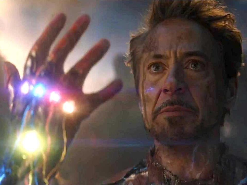 Robert Downey Jr. as Iron Man, holding up a gauntlet with six stones, in "Avengers: Endgame."
