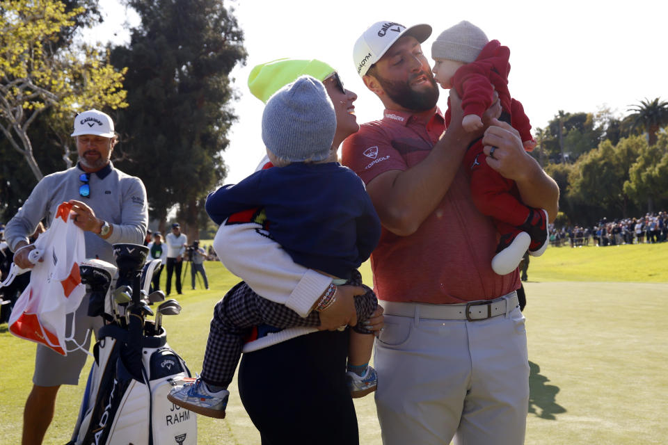 Jon Rahm celebrates with his family on the 18th green after winning the Genesis Invitational golf tournament at Riviera Country Club, Sunday, Feb. 19, 2023, in the Pacific Palisades area of Los Angeles. (AP Photo/Ryan Kang)