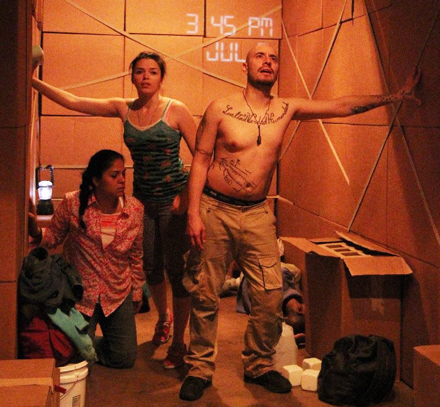 This theater publicity image released by DDPR Public Relations shows cast members during a performance of "LaRuta." The off-Broadway company Working Theater is presenting a play about immigrants sneaking across the border is being staged inside a 48-foot-long cargo container. (AP Photo/DDPR Public Relations, Lia Chang)