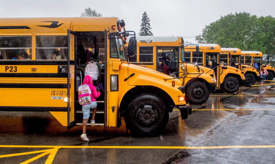 Hines Primary School students climb onto their buses after school Wednesday, April 28, 2021 in Peoria.