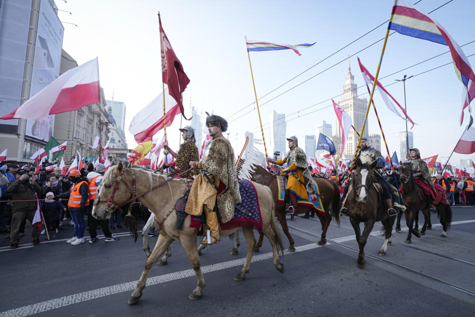 Riders wearing historic outfits take part the annual Independence Day march which turned violent in recent years because of the participation of right-wing groups, in Warsaw, Poland, on Thursday, Nov. 11, 2021. The Warsaw mayor and courts banned this year's event due to its history of violence, but the right-wing ruling authorities defied the ban and gave the march state event status to allow it to go ahead. (AP Photo/Czarek Sokolowski)