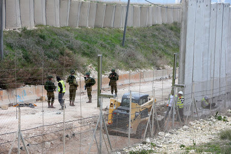 Israeli workers are seen building a wall near the border with Israel near the village of Naqoura, Lebanon February 8, 2018. REUTERS/Ali Hashisho