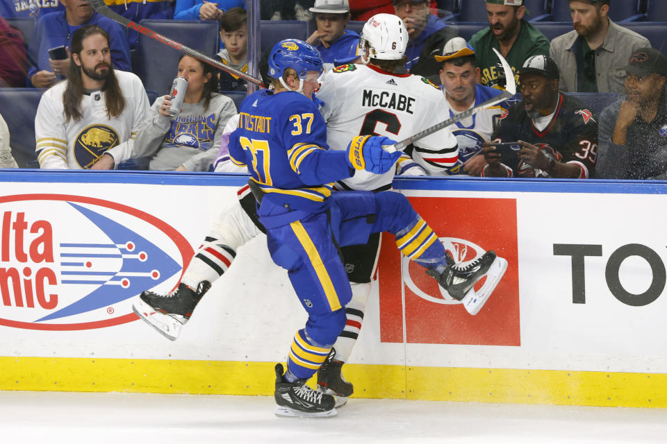 Buffalo Sabres center Casey Mittelstadt (37) and Chicago Blackhawks defenseman Jake McCabe (6) collide during the third period of an NHL hockey game, Saturday, Oct. 29, 2022, in Buffalo, N.Y. (AP Photo/Jeffrey T. Barnes)