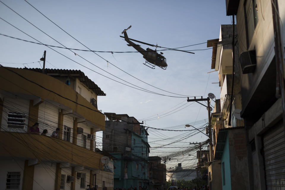 A military police helicopter flies over the Mandela shantytown, part of the Manguinhos slum complex, after attacks to their Pacifying Police Unit posts in Rio de Janeiro, Brazil, Friday, March 21, 2014. Rio de Janeiro police say suspected drug gang members on Thursday night attacked three police slum outposts and burned one of them. Officials say they'll ask for elite Brazilian federal police to help quell a wave of violence in supposedly pacified slums. (AP Photo/Felipe Dana)
