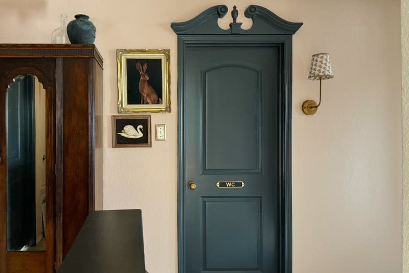 Deep blue door with ornate curved trim at the top after makeover