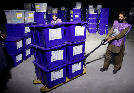 An Afghan election commission worker moves ballot boxes and election material in a warehouse in Kabul, Afghanistan October 18, 2018.REUTERS/Mohammad Ismail