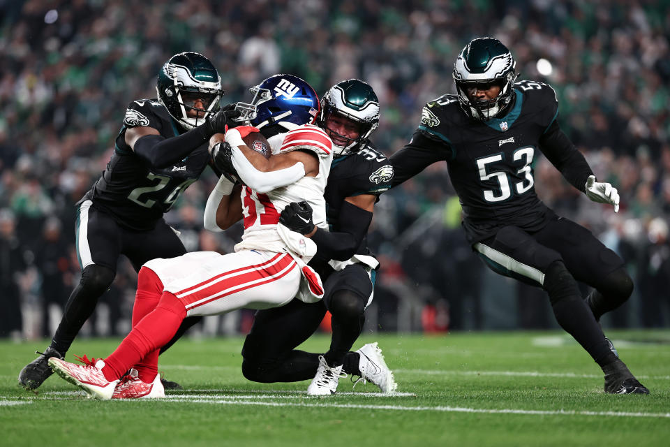 PHILADELPHIA, PENNSYLVANIA – DECEMBER 25: James Bradberry #24, Kevin Byard #31 and Shaquille Leonard #53 of the Philadelphia Eagles tackle Matt Breida #31 of the New York Giants during the second quarter at Lincoln Financial Field on December 25, 2023 in Philadelphia, Pennsylvania. (Photo by Dustin Satloff/Getty Images)