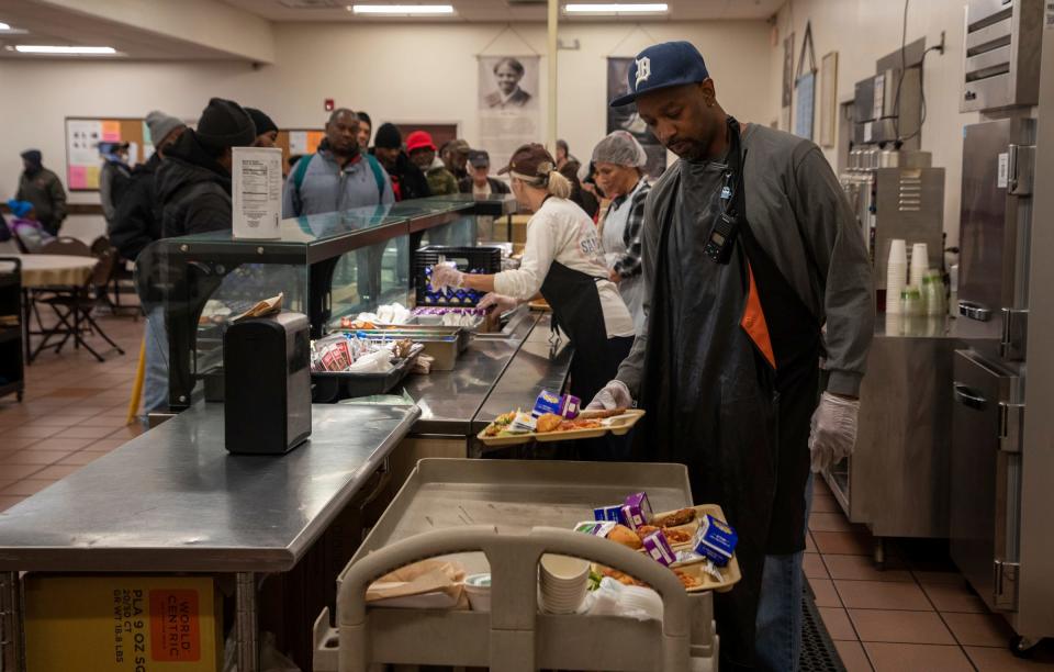 Maurice Thomas, a kitchen maintenance worker at Capuchin Soup Kitchen, loads a cart with platters of food in Detroit on Thursday, Dec. 7, 2023.