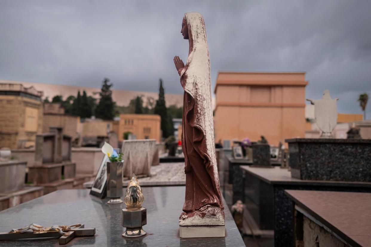 <span>A statue at San Brunoni cemetery in Taranto covered with ferrous dust from the neighbouring steel factory.</span><span>Photograph: Roberto Salomone/The Observer</span>