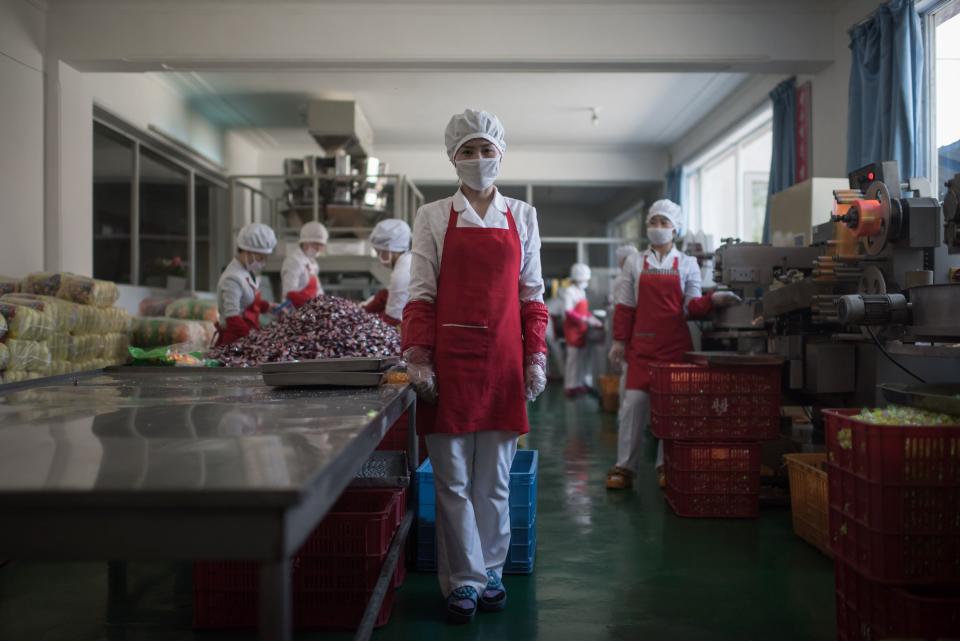 Hong Kum-Ju, 27, poses for a portrait at the food factory where she works, in the eastern port city of Wonsan.