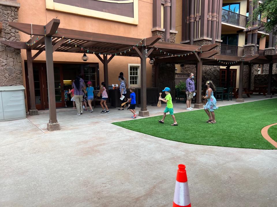 Kids playing outside and walking into a building.