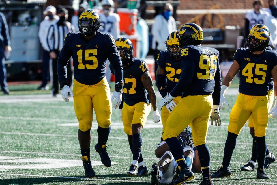 Michigan defensive lineman Christopher Hinton, left, celebrates a tackle against Penn State during the first half at Michigan Stadium in Ann Arbor, Saturday, Nov. 28, 2020.